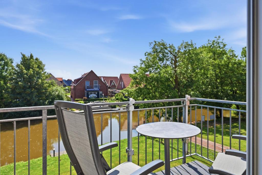 a patio with a table and chairs on a balcony at Grachtenrefugium in Greetsiel