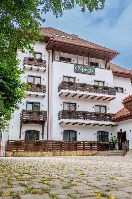 a large white building with balconies and a sign on it at Expecto Apartments in Sinaia