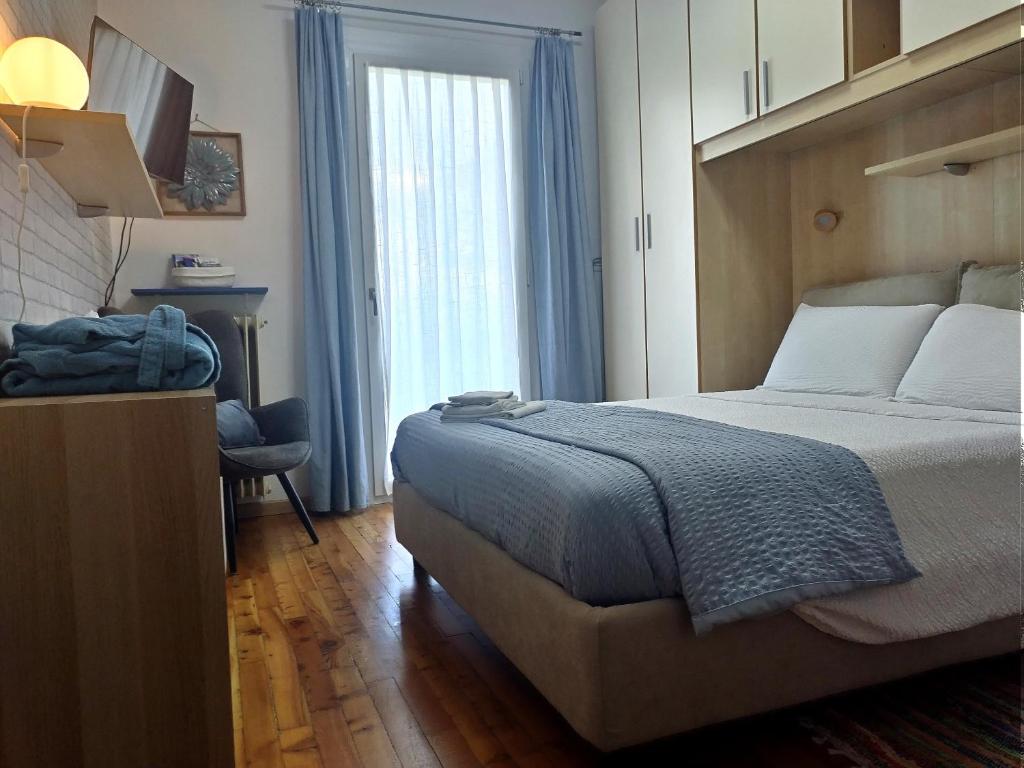 a bedroom with a bed and a desk and a window at La casetta di Elena - Sondrio Valtellina in Sondrio