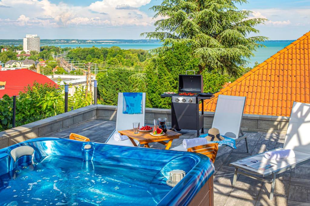 a hot tub on a balcony with a view of the ocean at Apartman 360 in Balatonalmádi