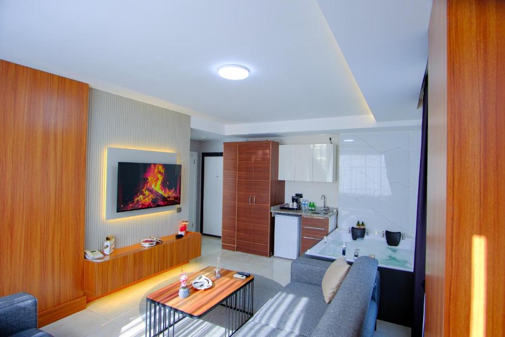 a living room with a couch and a kitchen at Gala Mtm Konaklama in Çiftlikköy