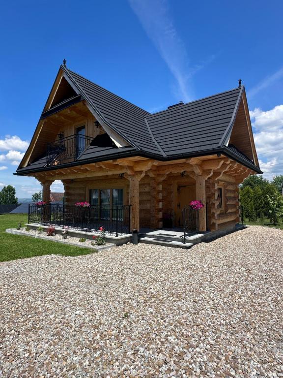 a log cabin with a black roof at Osada Groń in Groń