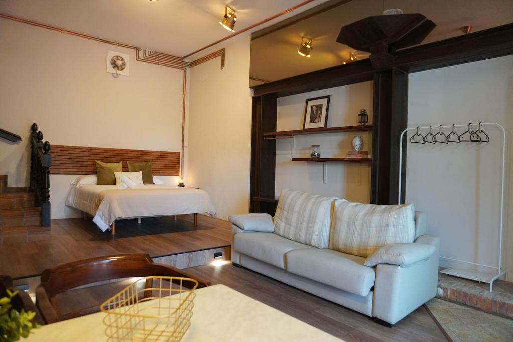 a living room with a bed and a couch at Loft Pedreña Studio in Pedreña