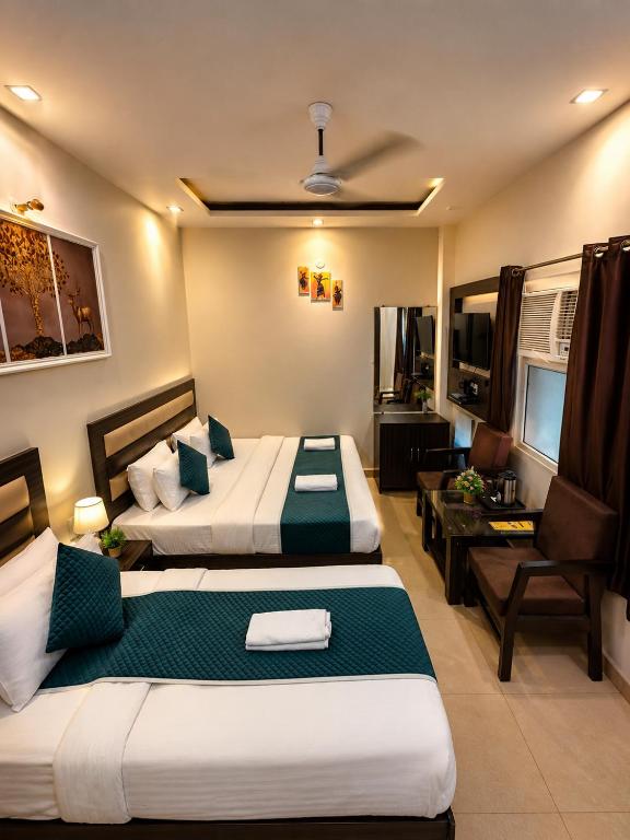 a bedroom with two beds and a living room at Hotel Gopal in Haridwār