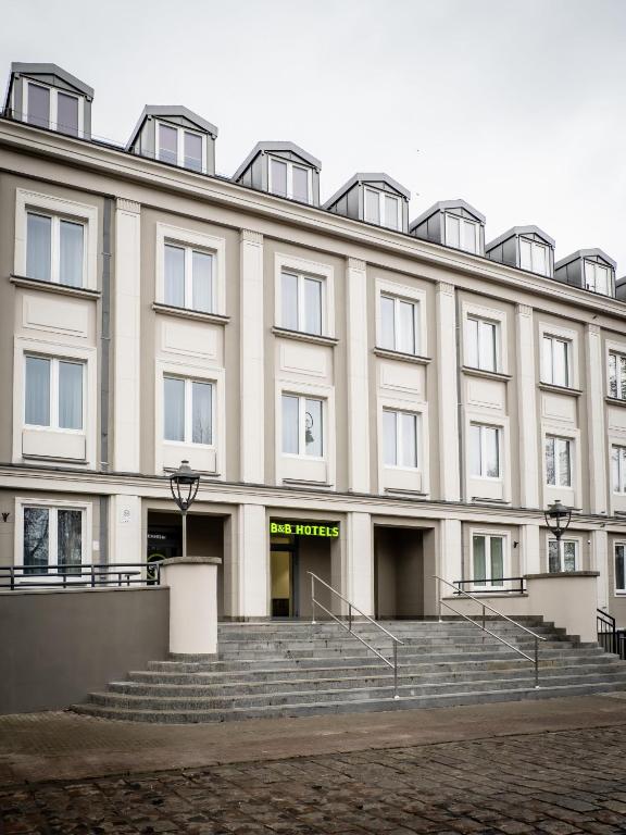 a large building with stairs in front of it at B&B HOTEL Kalisz Centrum in Kalisz