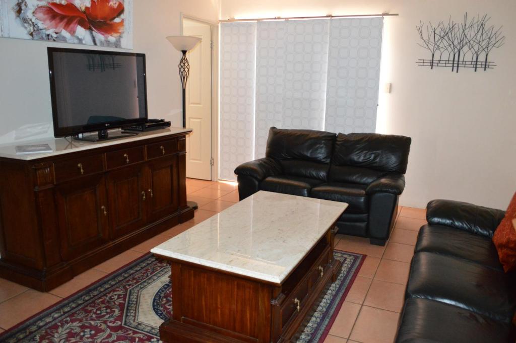 a living room with a couch and a flat screen tv at Ruthmor Villas in Toowoomba