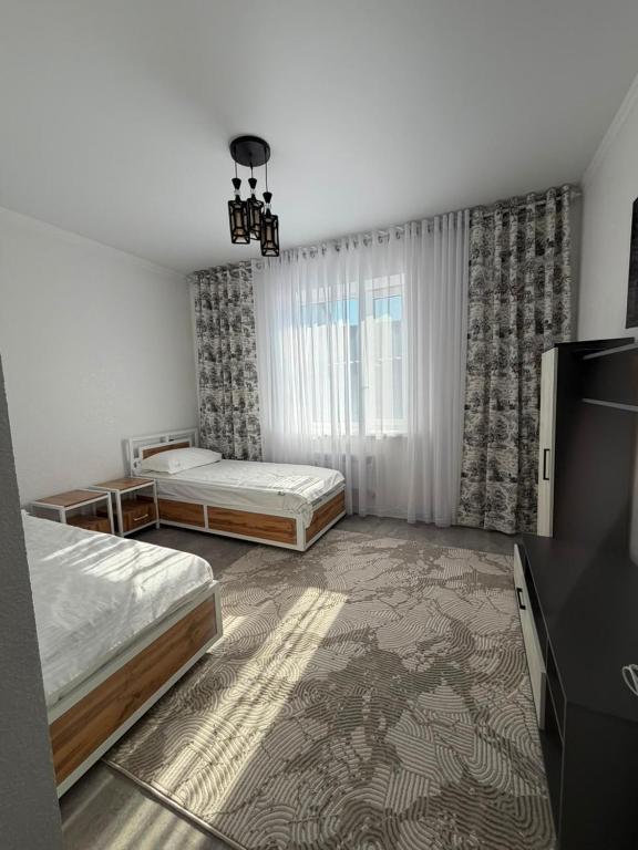 a bedroom with two beds and a television in it at Kol-Ukok Hotel in Bol'shevik
