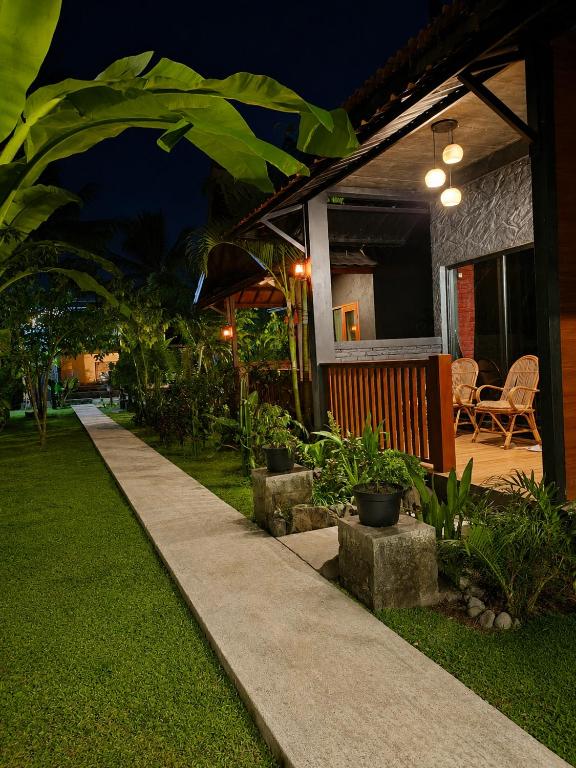 a house with a pathway in front of it at night at Tetebatu Valley Bungalows in Tetebatu