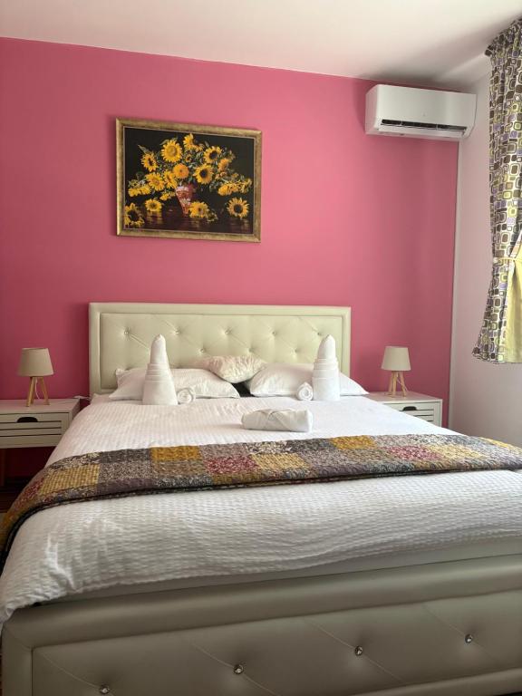 a bedroom with pink walls and a large bed at Casa Maya with private parking in Oradea
