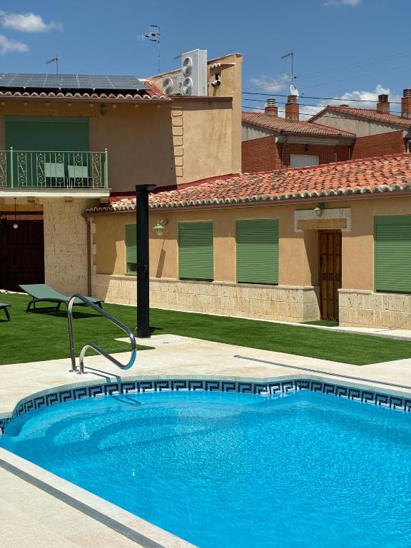 a swimming pool in front of a house at El gallinero de Valoria in Valoria la Buena