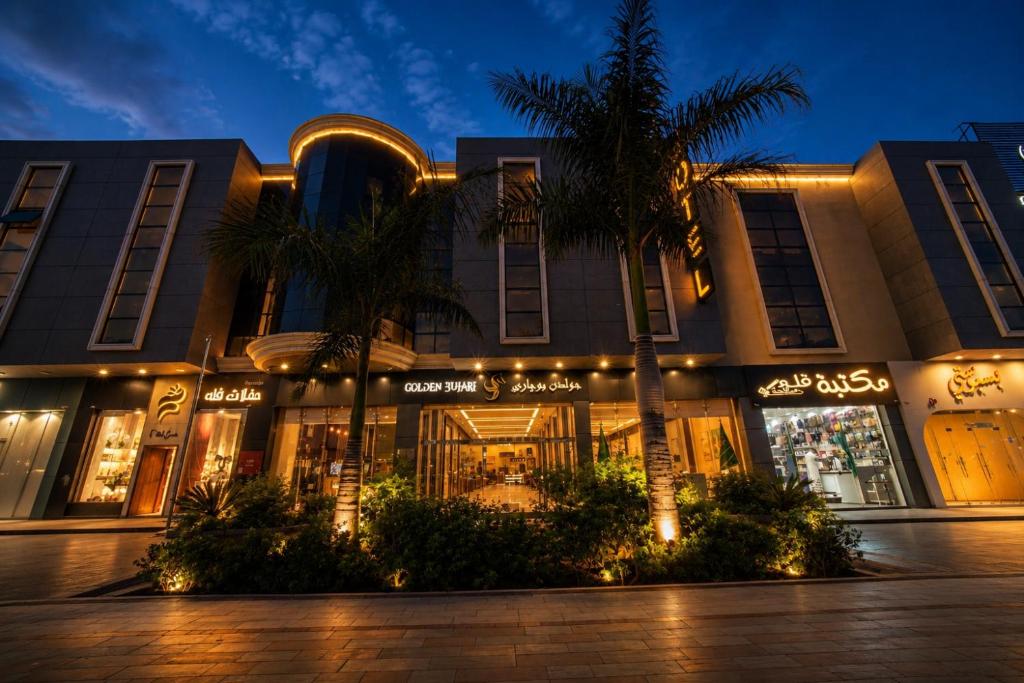 a building with a palm tree in front of it at جولدن بوجاري الضيافه in Khamis Mushayt
