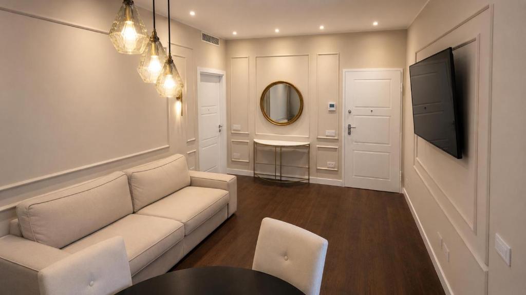 a living room with a couch and a table and a mirror at Appartamento Doglio Lux in Cagliari