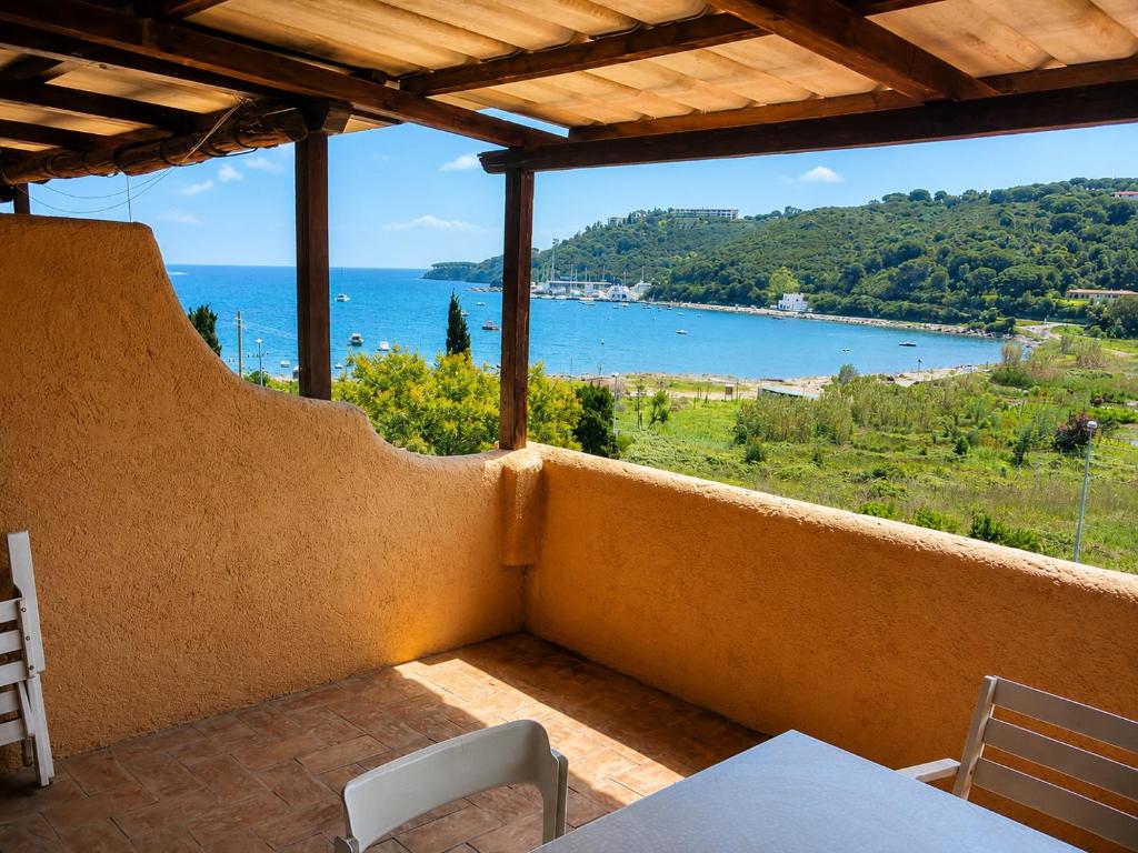 a balcony with a table and chairs and a view of the ocean at Apt. Portolano By SolturElba in Porto Azzurro