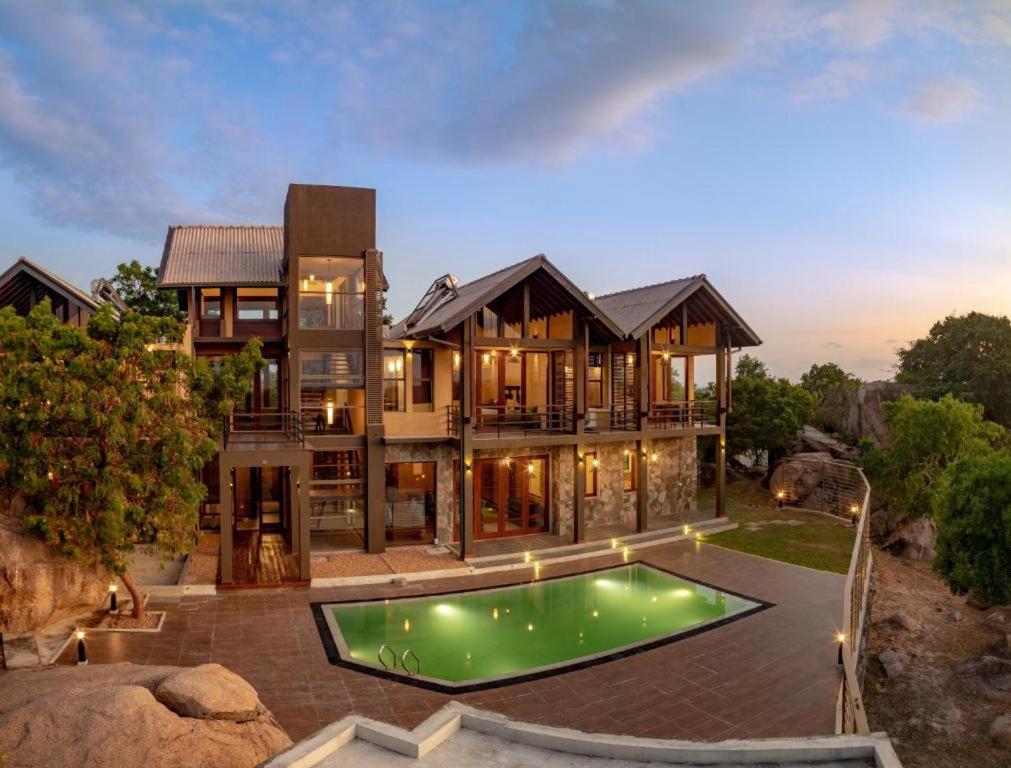 a house with a swimming pool in front of it at Rock Wild Yala in Yala