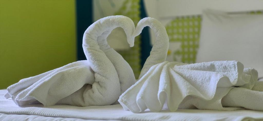 a pair of towel swans sitting on a bed at Okeania Seafront Rooms in Kamena Vourla in Kamena Vourla