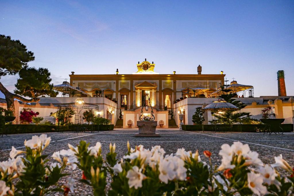 an exterior view of a mansion with a fountain at Villa del Gattopardo in Palermo