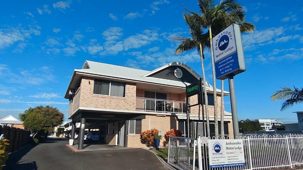 a house with a sign in front of it at Ambassador Motor Lodge in Hervey Bay