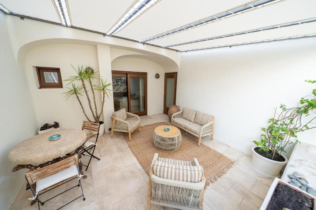 a living room with a table and chairs at Hotiday Elite Olea Sanctuary in Olbia