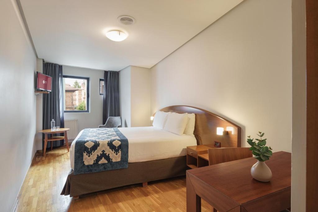 a hotel room with a bed and a table at Exe Hotel El Magistral in Oviedo