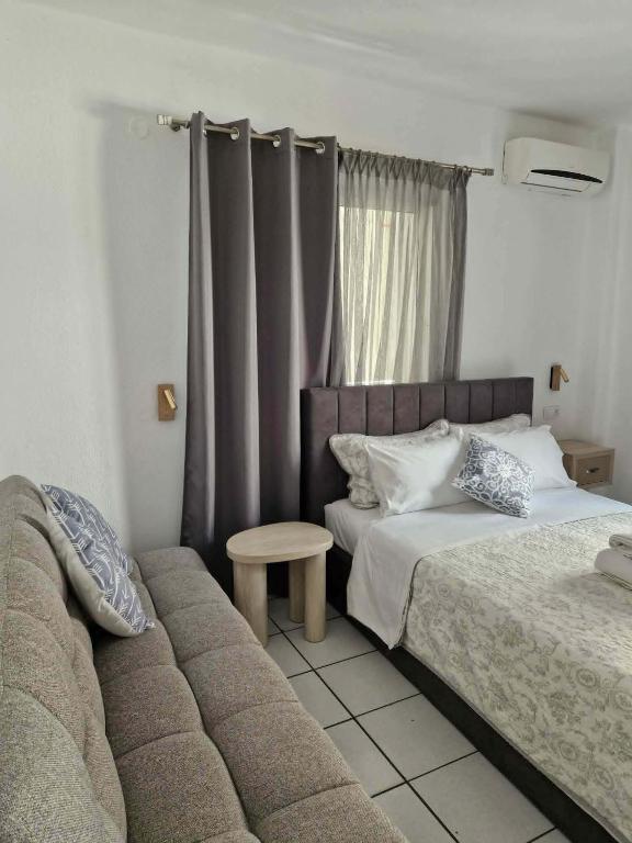 a hotel room with two beds and a couch at Olimpus Sunset Studio in Paralia Katerinis