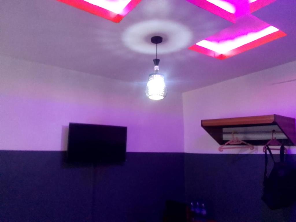 a room with purple walls and a ceiling with a light at Palmgroove Hotel AND Bar, IDANYIN, IPERIN,OGUN STATE in Obisesan