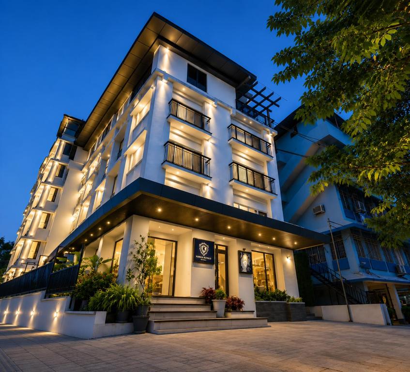 a large white building with lights on it at K Grandeur Hotels- South Railway Station in Cochin