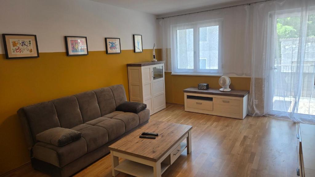 a living room with a couch and a coffee table at Appartement LUFT bei Wien in Klosterneuburg