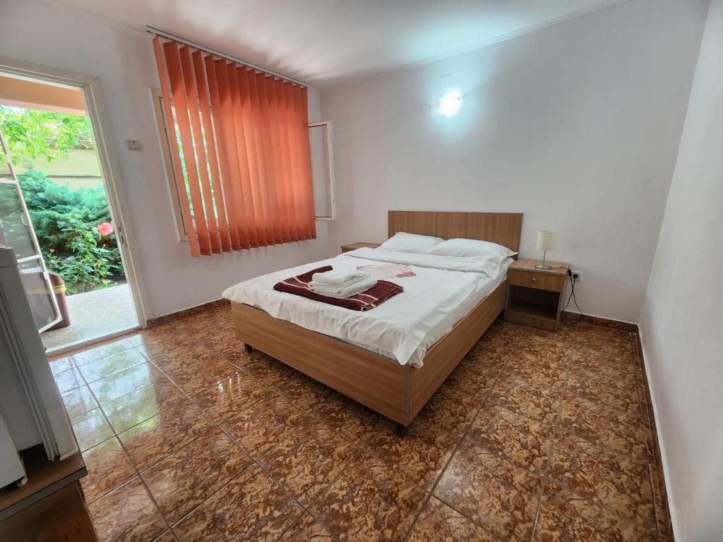 a bedroom with a bed and a large window at La Livadă in Vama Veche