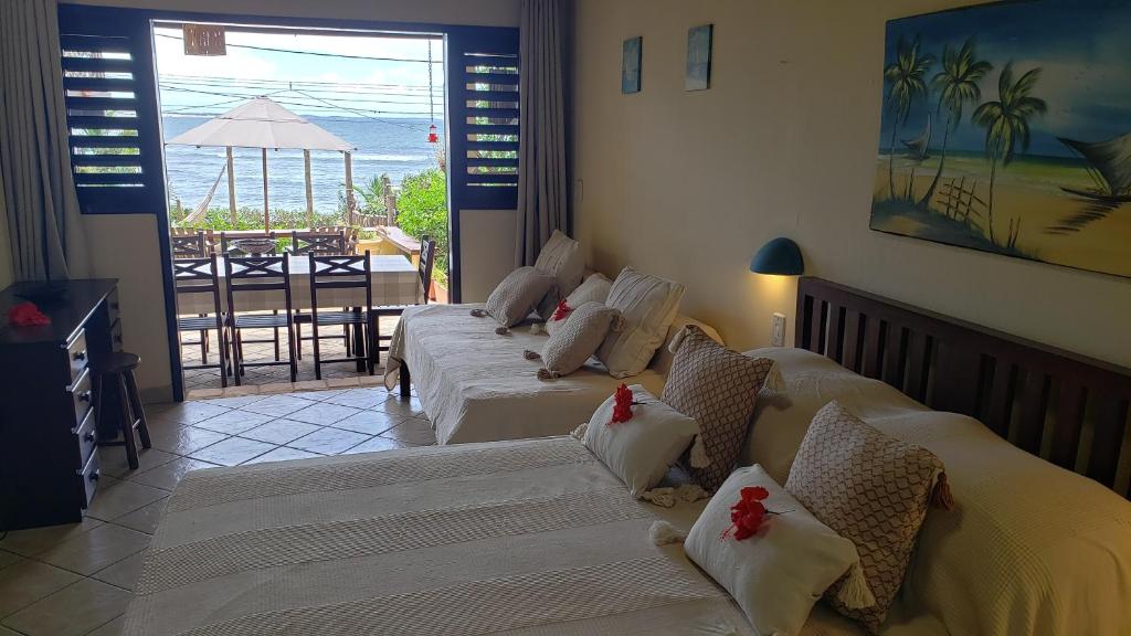 a room with three beds with a view of the ocean at Casa Serena in Pipa