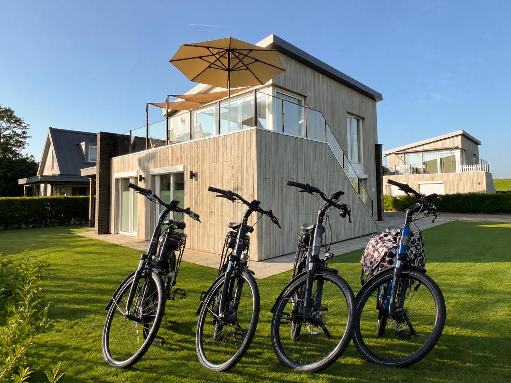 a group of bikes parked in front of a house at Villa Maroma Mistral Veerse Meer, gratis 4 E-bikes, gratis laden EV, trampoline in Kamperland