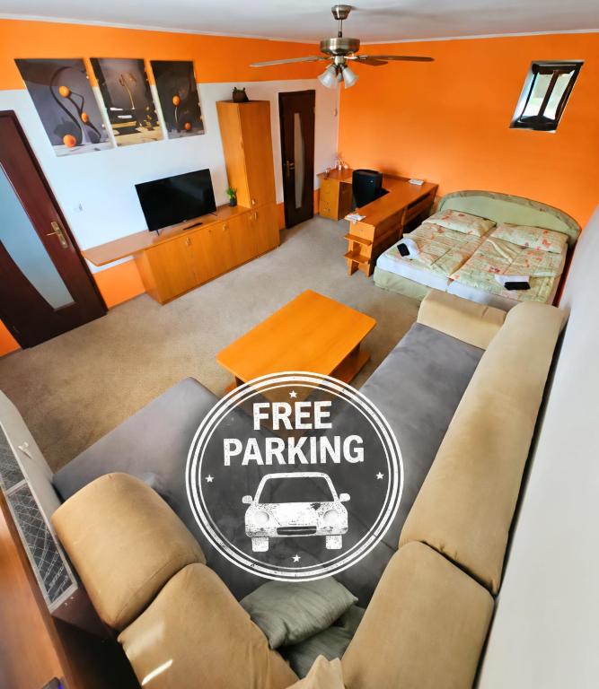 a living room with a couch and a free parking sign at WOLF APARTMAN Luxusné ubytovanie s plnou výbavou s Bezplatným parkovaním SMART TV a Optickým Internetom Priamo v Považskej Bystrici Tichá lokalita s Všade blízko Vhodné pre Jednotlivcov Rodiny Pracovné cesty Turistiku aj Oddych Plne vybavená Kuchyňa in Považská Bystrica