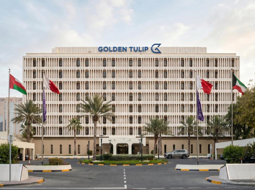 a building with a sign on top of it at Golden Tulip Bahrain in Manama