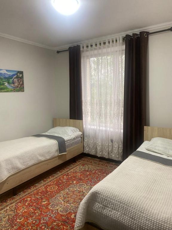 a bedroom with two beds and a window at Khan-toru in Pokrovka