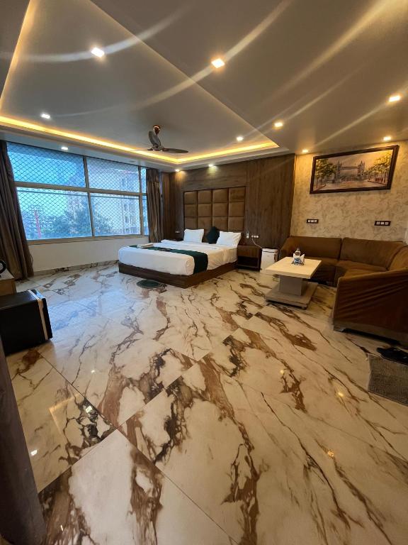 a large room with a bed and a marble floor at Hotel V Square in Lucknow