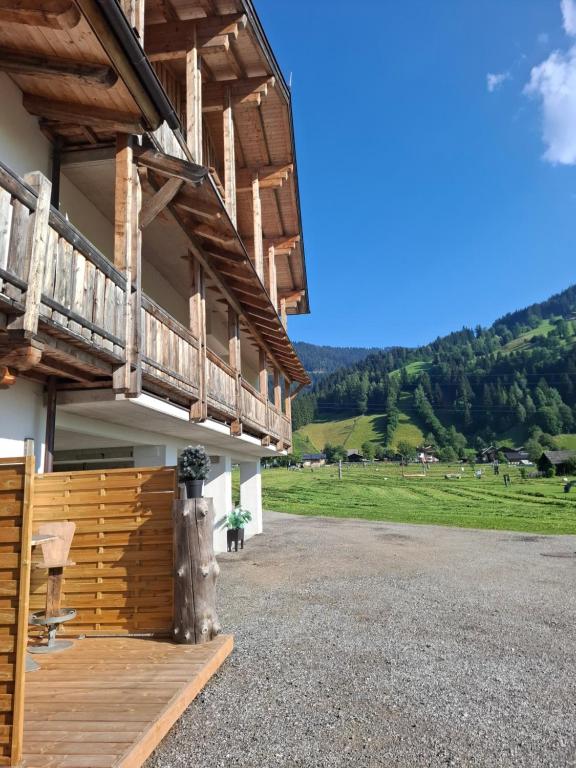 a large building with a balcony and a green field at Appartements Baumanngut in Wagrain