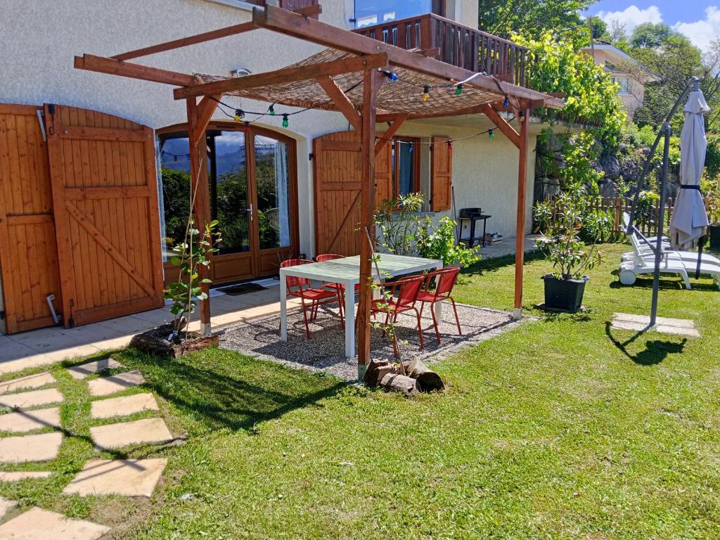 a patio with a table and chairs in a yard at L'Aparté Nature, entre campagne et montagne in Jarrie