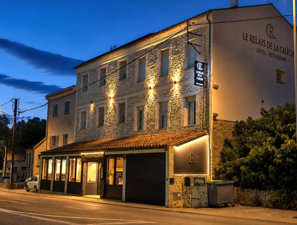 a building with lights on the side of a street at Le Relais de la Calèche in Le Beausset