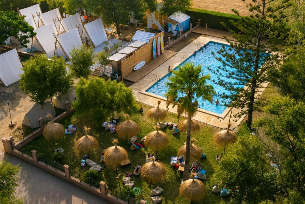 an overhead view of a swimming pool with people sitting around it at Kampaoh El Palmar in El Palmar