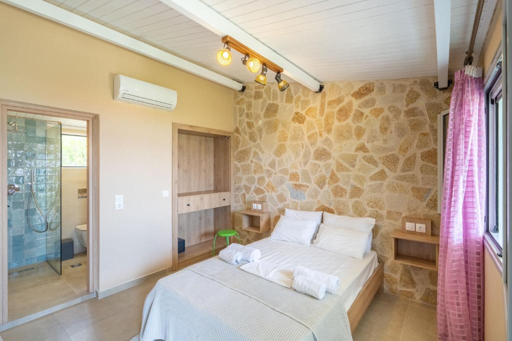 a bedroom with a bed and a stone wall at Matina Studios in Nikiana