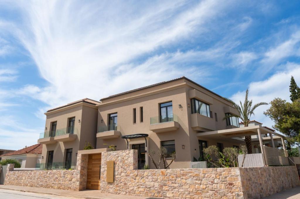 a house with a stone wall in front of it at Aetheria Boutique Hotel & Spa in Markopoulo