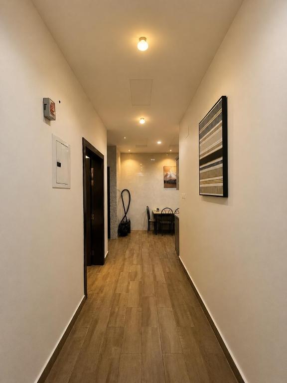 a hallway with white walls and wooden floors at قنوف-شقة فندقية خاصة ذ in Abha