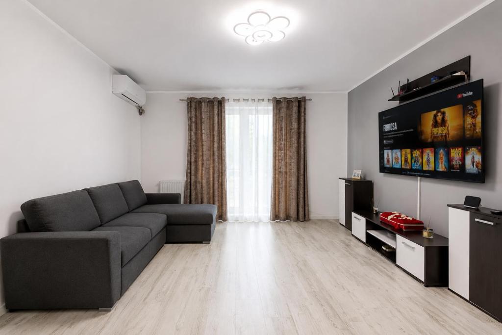 a living room with a couch and a flat screen tv at Apartament Rovine in Craiova