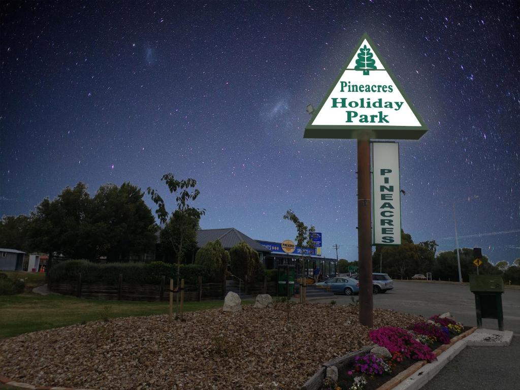 a pharmacy holiday park sign in front of a parking lot at Pineacres Motel and Park in Kaiapoi