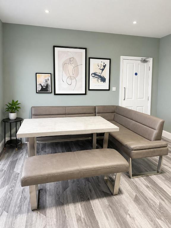 a living room with a table and two benches at The Stables in Market Rasen
