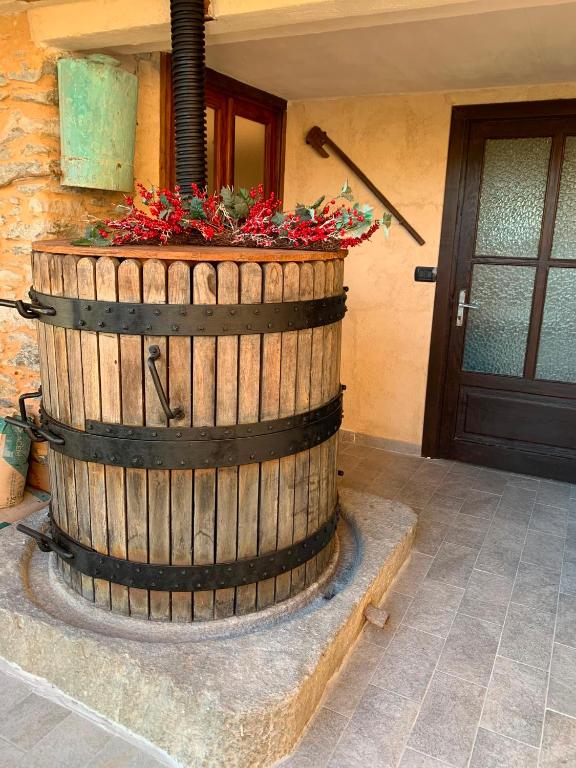 a wooden barrel with flowers in it next to a door at El Torch di Long Elisa in San Garmano Chisone