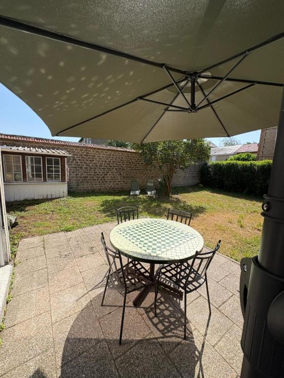 a table and chairs under an umbrella on a patio at La belle époque ardennaise in Sedan