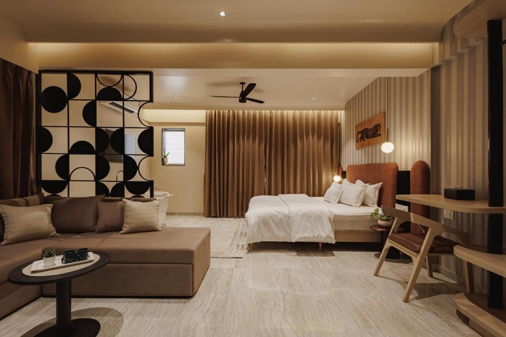 a hotel room with a bed and a couch at Abhibha Suites Waterfront in Pune