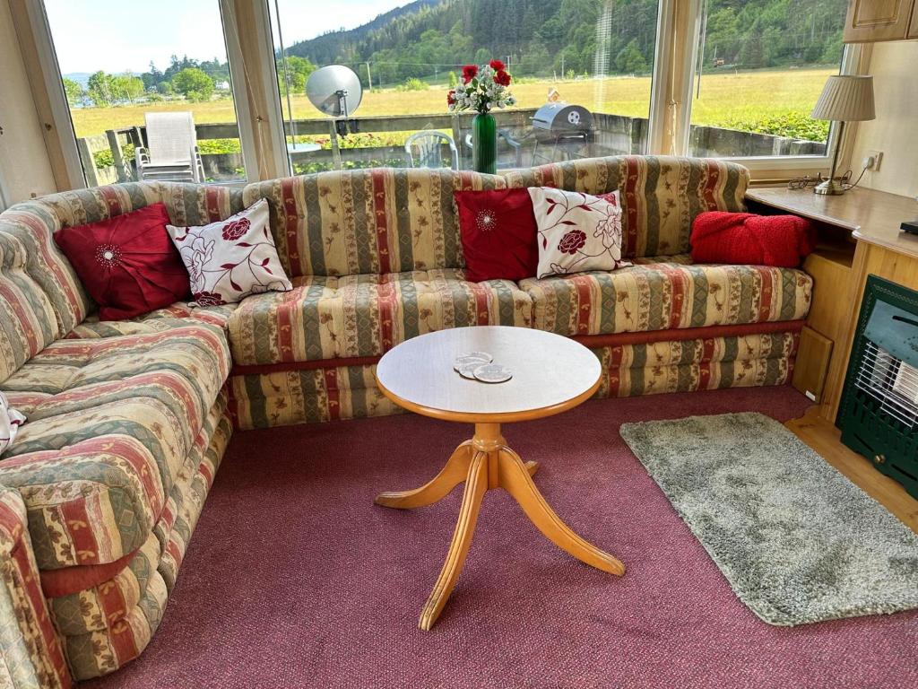 a living room with a couch and a table at Cosalt Sea View 18 in Ardentinny