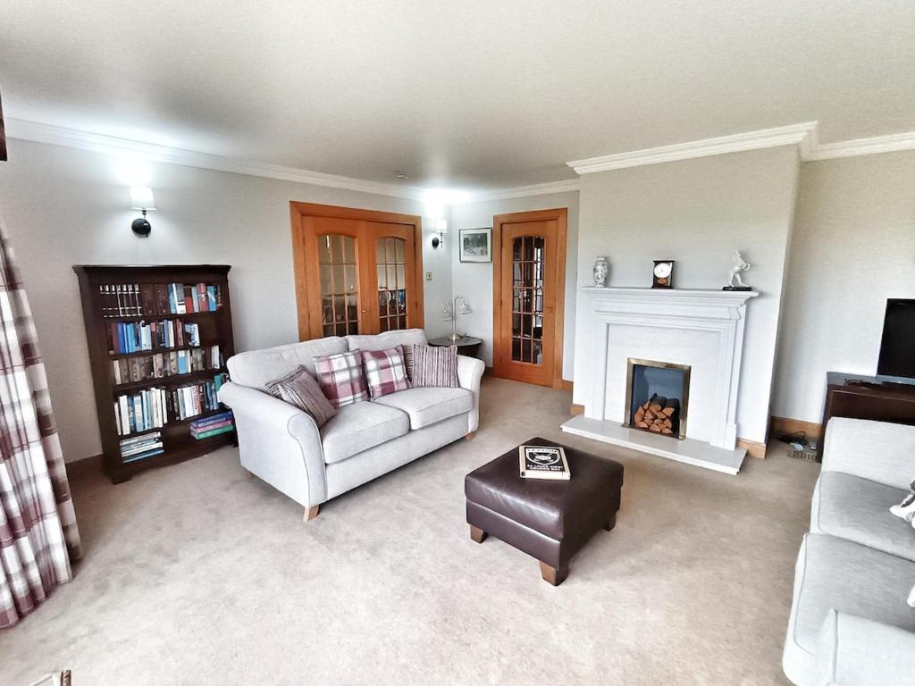 a living room with a couch and a fireplace at Golf View, Cruden Bay in Cruden Bay