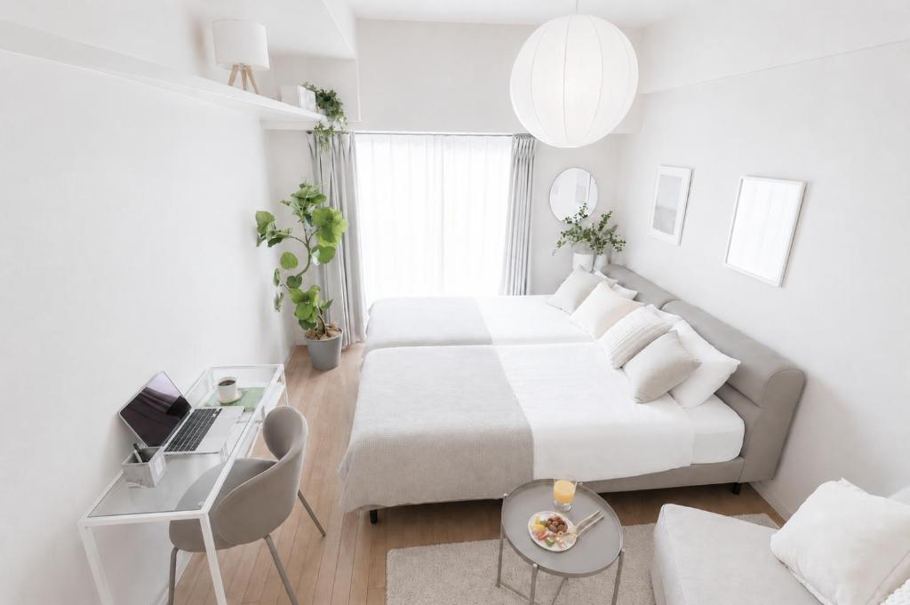 a white bedroom with a bed and a couch at Miroku Nagoya in Minami-sotoborichō